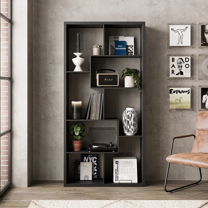 Tall matt black industrial bookcase styled with vinyls, plants and monochrome decor, perfect storage accent for an urban loft bedroom.
