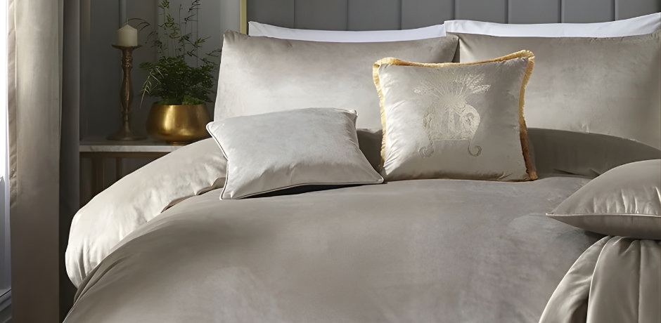 Taupe velvet bedding with matching cushions and coordinating taupe curtains in a calm, neutral bedroom.