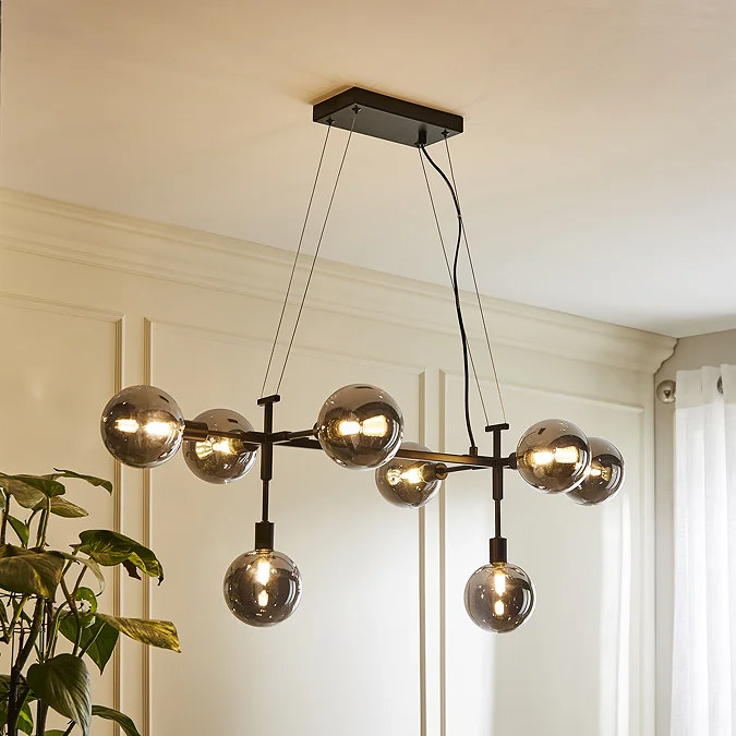 Black metal Sputnik‑style chandelier with eight smoked‑glass globes, ideal statement lighting for an industrial bedroom design.