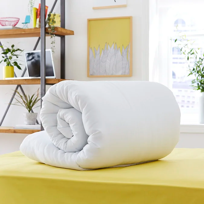 White duvet layered over butter yellow fitted sheet.