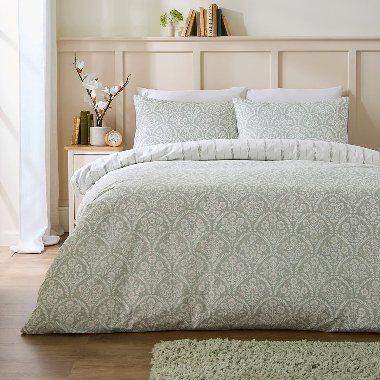 Green patterned duvet set in a light neutral bedroom.