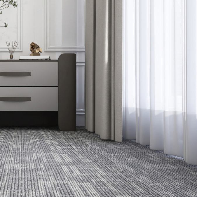 Bedroom corner with thick carpet, grey curtains and modern chest of drawers for added warmth