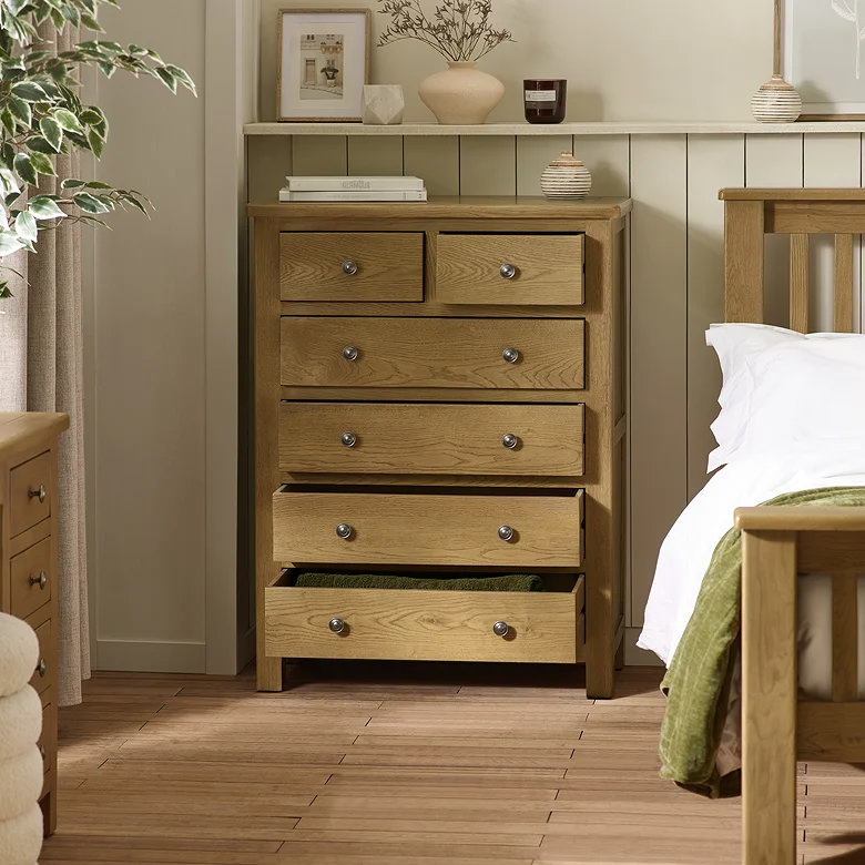 oak chest of drawers in earthy bedroom with warm wood tones and neutral styling