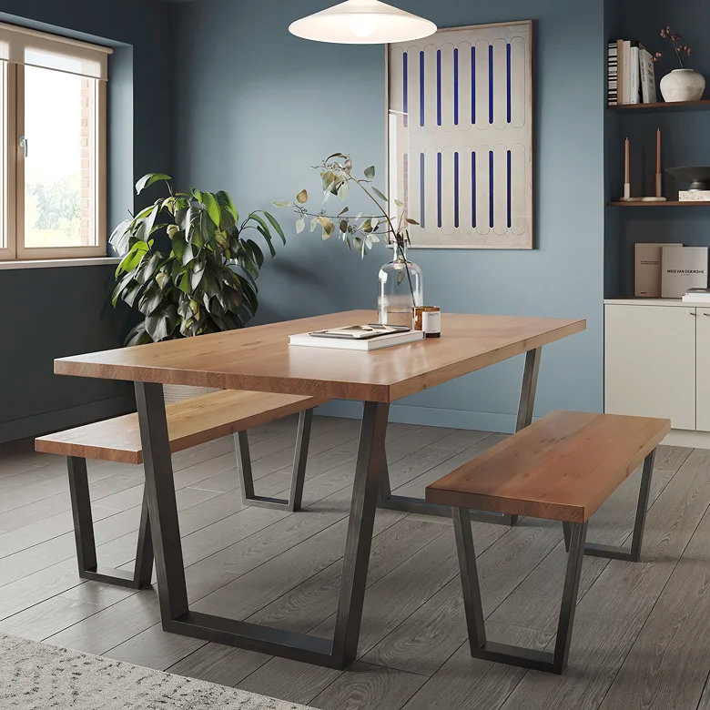 oak and black dining table with bench seating in moody blue dining room with earthy styling