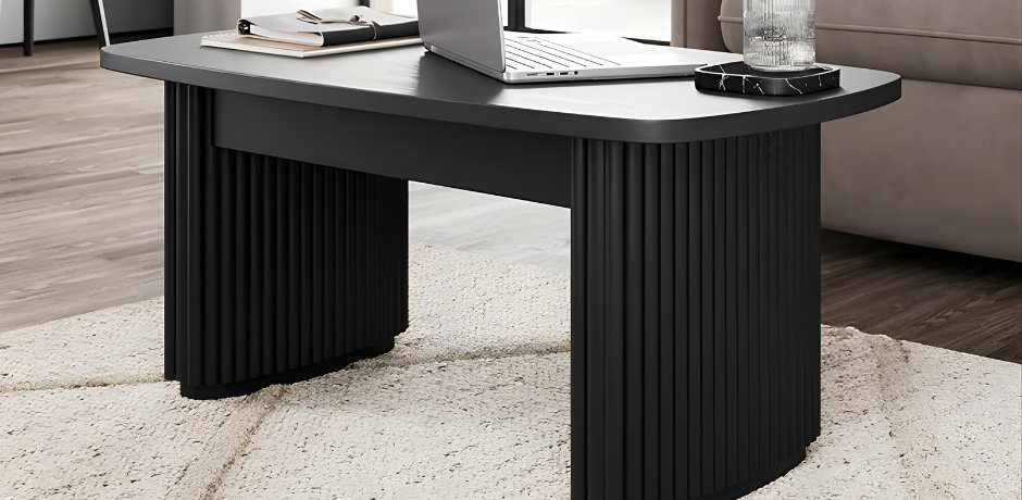 Cream textured office rug under a modern black desk with a laptop, showing how a soft neutral rug warms a work-from-home setup and defines the workspace