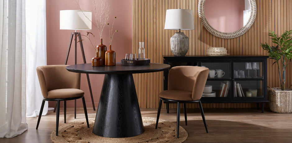 Soft-tan velvet dining chairs paired with a black round pedestal dining table in a modern wood-slat dining room.