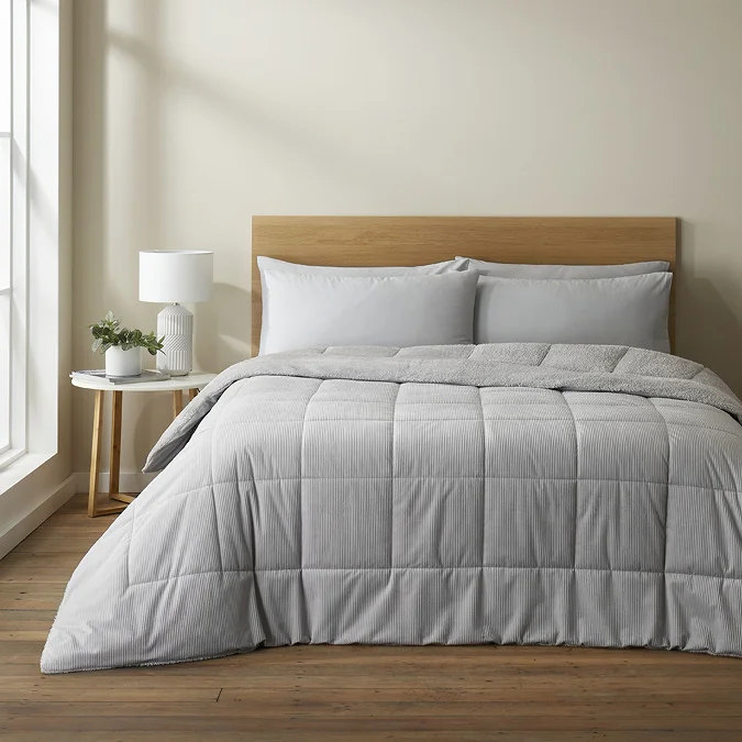 Grey coverless duvet on oak bed