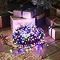 multi-coloured christmas lights wrapped up in a circle on a wooden floor, lit up in the dark