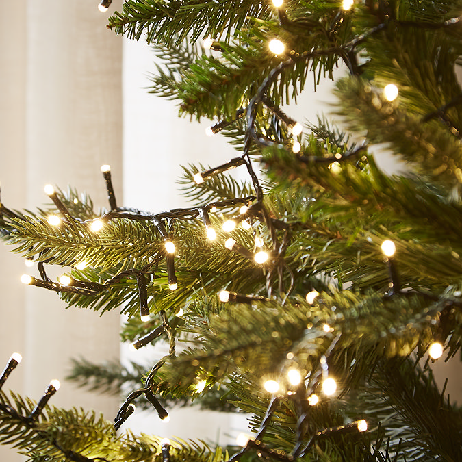 close up on warm white LED lights displayed on a green tree
