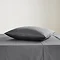 square coloured pillow in charcoal grey pillowcase, resting on matching flat sheet on bed