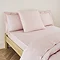 Blush pink square pillowcase on bed