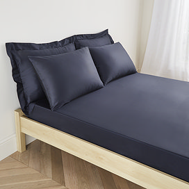 mattress on a bed covered with dark blue fitted sheet in 30cm depth, with matching pillowcases