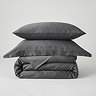 image of charcoal grey duvet cover folded up with matching oxford and standard pillows stacked on top