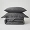 image of charcoal grey duvet cover folded up with matching oxford and standard pillows stacked on top