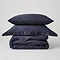 dark blue duvet cover folded with matching oxford and standard pillows stacked on top
