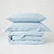 image of light blue duvet cover folded with matching oxford and standard pillows stacked on top, with plain white background