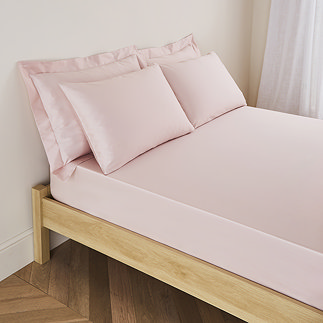 mattress on a bed covered with pale pink fitted sheet in 30cm depth, with matching pillowcases