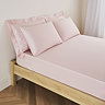 mattress on a bed covered with pale pink fitted sheet in 30cm depth, with matching pillowcases