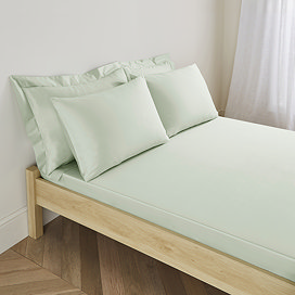 side-on image of sage green sateen fitted sheet on mattress with standard (25cm) depth