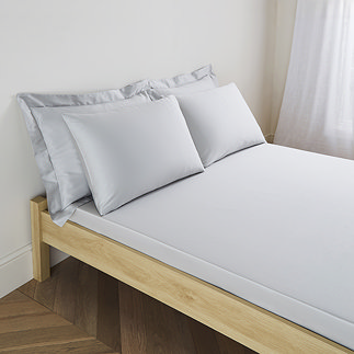 mattress on a bed covered with silver fitted sheet in standard size, with matching pillowcases