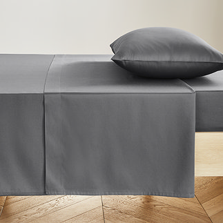 charcoal grey flat sheet pressed neatly on a bed with matching pillowcase