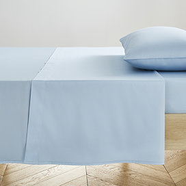 light blue flat sheet pressed neatly on bed with matching pillow