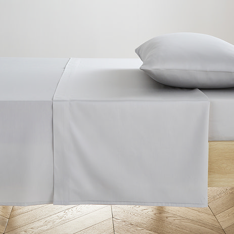 silver flat sheet pressed neatly on bed with matching pillow