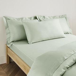 Plain Dye Kingsize Pillowcase in Sage on bed image 1
