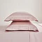 Oxford Pillowcase pair in Blush on a bed image 2