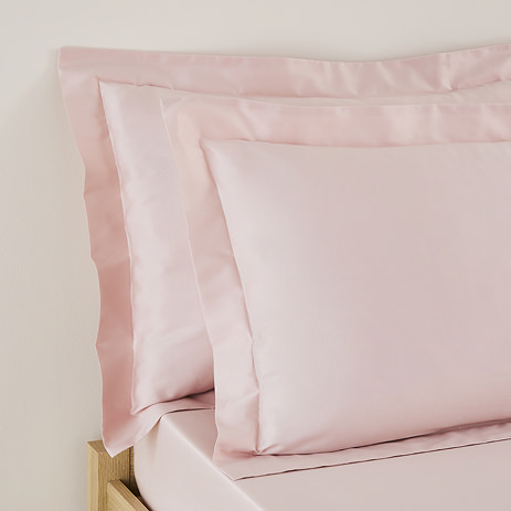 Oxford Pillowcase pair in Blush on a bed image 1
