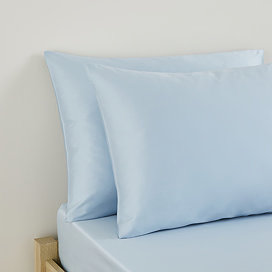 close up on pair of pillows in light blue pillowcases