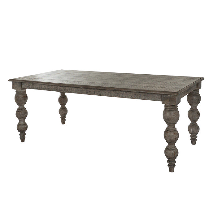 image cut out on white background of rectangular dark brown rustic dining table with carved legs