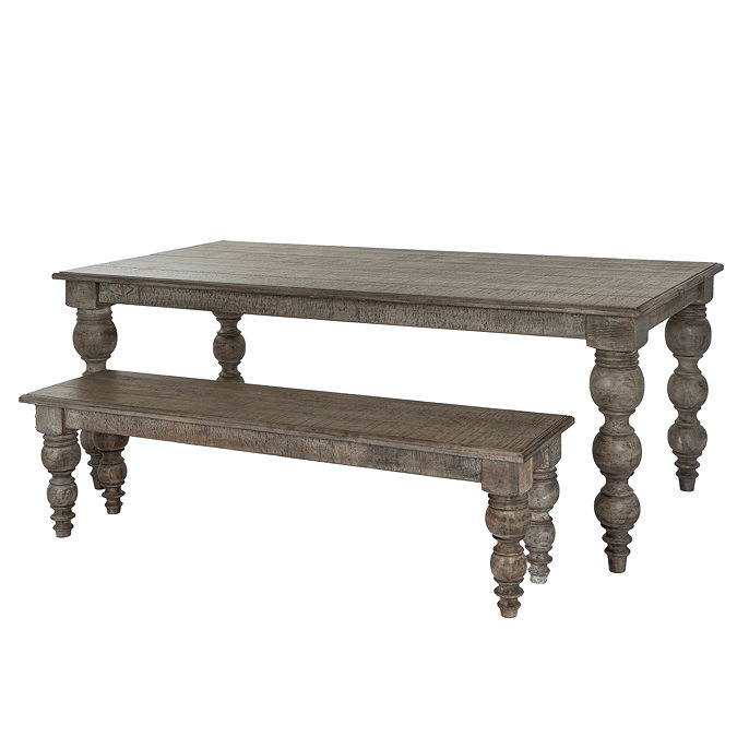 image cut out on white background of rectangular dark wood dining table with carved bobbin legs, and matching bench