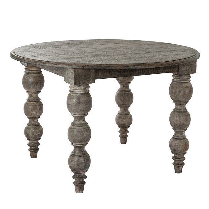 image cut out on white background of round dark brown rustic dining table with carved legs