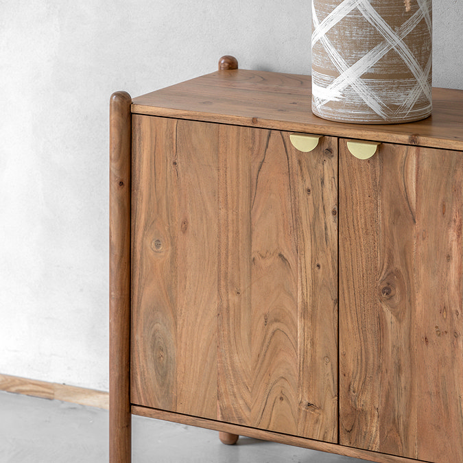 close up image of acacia wood four door sideboard with gold handles