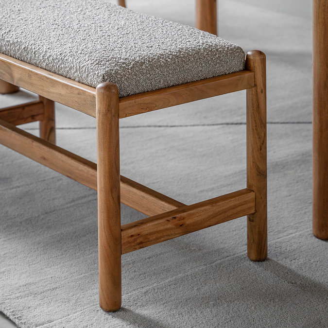 close up on acacia wood legs of bench, with grey boucle cushioned seat
