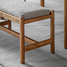 close up on acacia wood legs of bench, with grey boucle cushioned seat