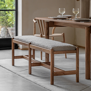 close up on acacia wood legs of bench, with grey boucle cushioned seat