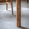 close up image of slim legs of acacia wood dining table