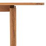 close up image of where slim acacia wood leg attaches to tabletop of dining table
