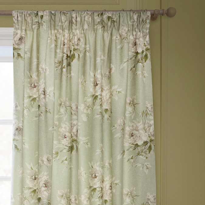Adele Sage Green Floral Pencil Pleat Curtains in front of a window close up image