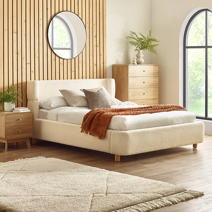 image of beige boucle textured bed with gently curved headboard, against slatted wood wall