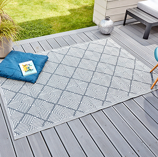 image of rectangular geometric patterned slate grey rug on grey patio