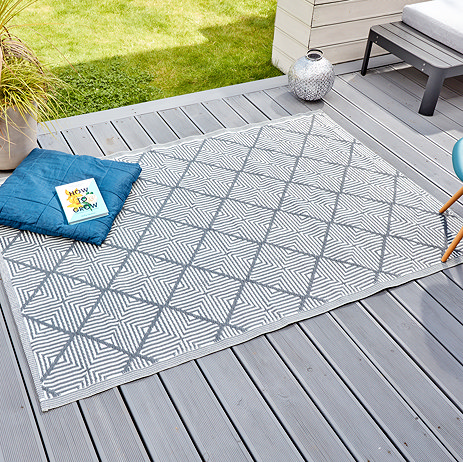 image of rectangular geometric patterned slate grey rug on grey patio