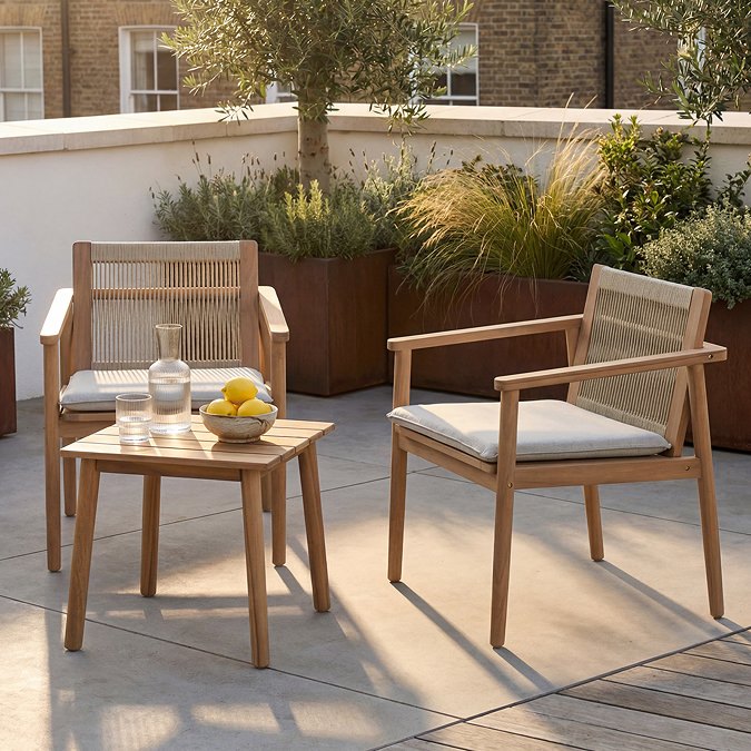 side on image of classic wooden bistro chairs and table, lit by sun and half in shade on a balcony