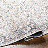 image of grey and blush pink floral rug folded slightly to show its thinness