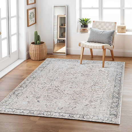 image of blush rug with grey and soft blue floral patterns, on light wood flooring of modern apartment