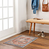 image of small version of rustic vintage rug in orange and blue shades on wood flooring in front of door