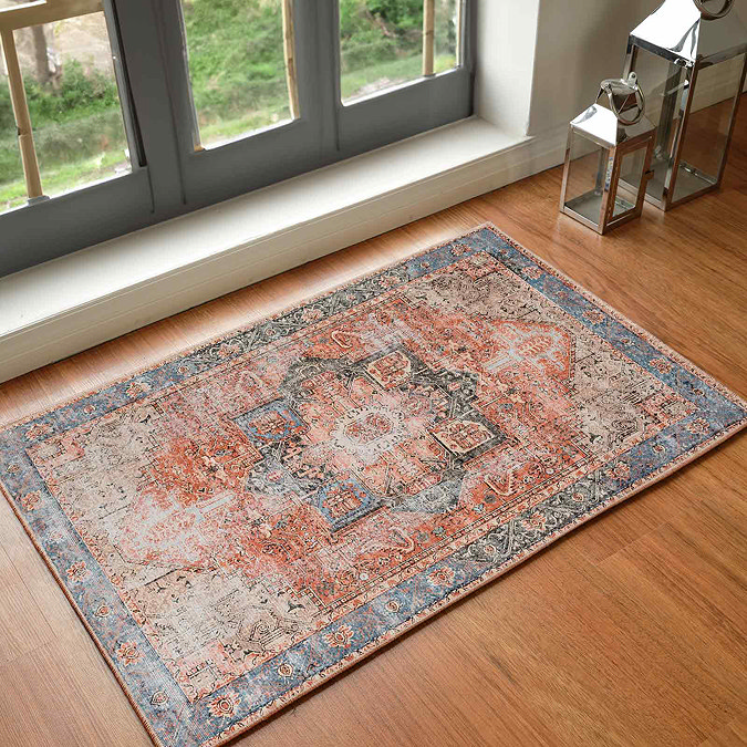image of rust coloured rug with faded blue border, on wood flooring of modern apartment