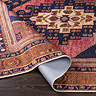 image of orange and red boho rug folded slightly to show its pile